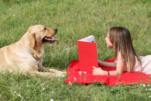 Little girl reading to her dog.